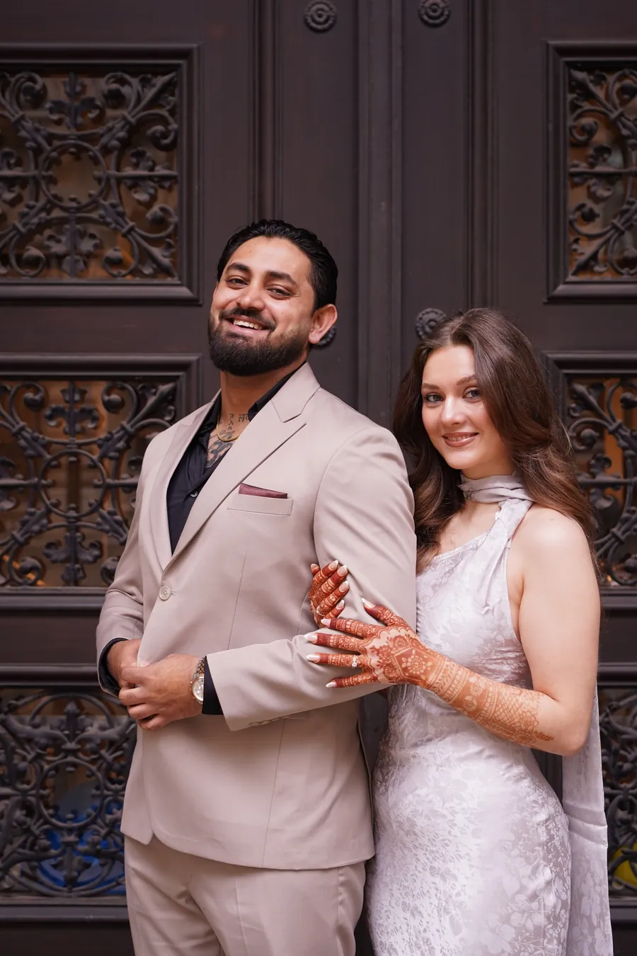 Die Gründer Sanni Singh Kakkar und Zelin Lee Ann Kakkar vor einer geschnitzten Holztür